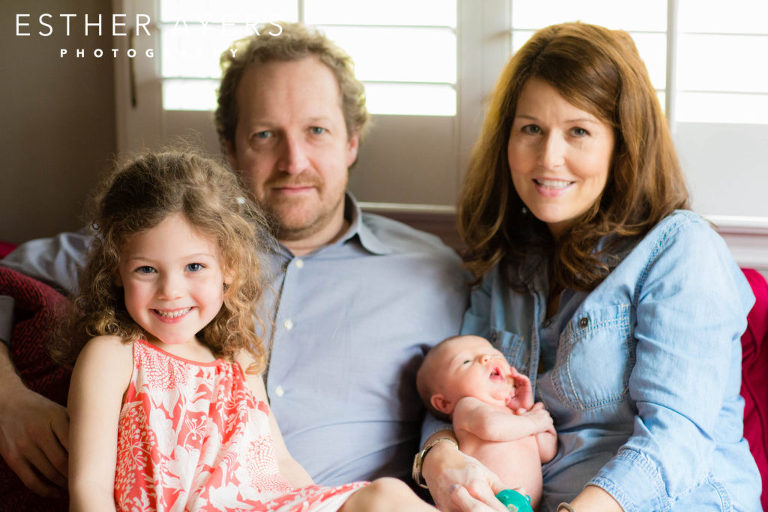 Happy parents smiling with little girl and newborn baby girl