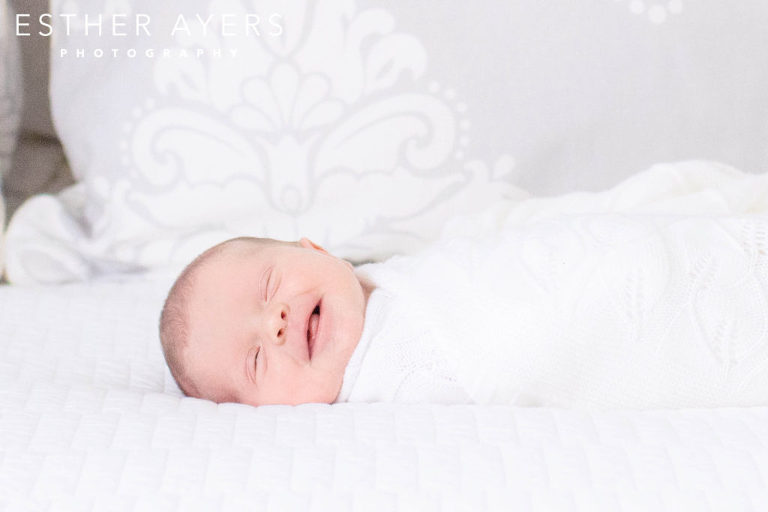 Newborn Baby Girl laughing on Bed