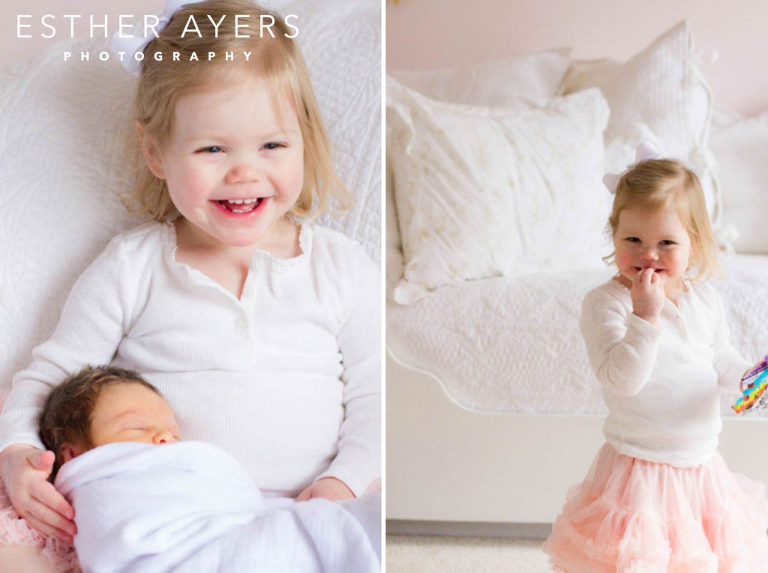 Big sister in pink tutu holding newborn baby girl