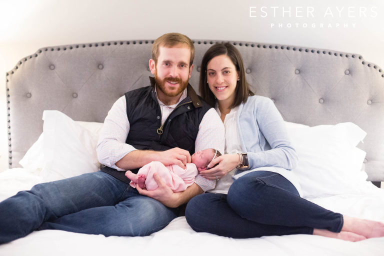 new mom and dad on bed with newborn baby girl